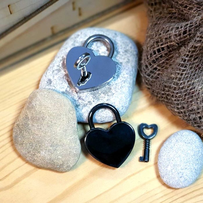 Divas piekaramās slēdzenes ar atslēgām melna un sudrabota uz akmens fona